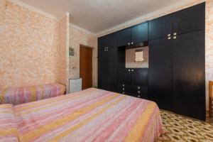 a bedroom with two beds and black cabinets at Casa vacanza Elena in Sarroch +23 photos