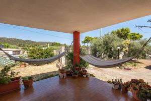 a porch with two hammocks and potted plants at Casa vacanza Elena in Sarroch