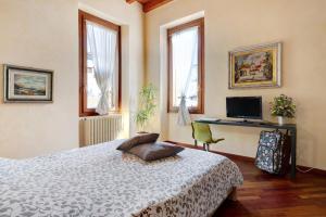a bedroom with a bed and a desk and windows at Wakesurfhouse 2 in Sulzano