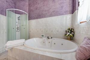a bathroom with a tub and a shower with purple walls at Wakesurfhouse 2 in Sulzano +21 photos