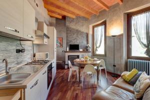 a kitchen and living room with a couch and a table at Wakesurfhouse 2 in Sulzano
