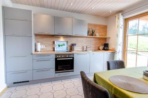 a kitchen with white cabinets and a table at Vordersbergerhof in Hausach