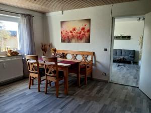 a dining room table with chairs and a painting on the wall at Apartment Flora in Stockach
