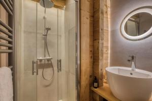 a bathroom with a shower and a white sink at Chalet des joux in La Clusaz +34 photos