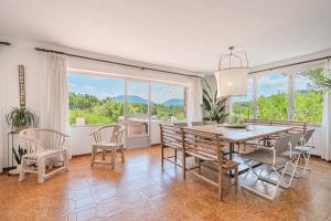a dining room with a table and chairs and windows at Villa Son Bibiloni in Algaida