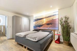a bedroom with a bed with a painting on the wall at Treibholz - Feriendomizil Ostsee in Schönberger Strand