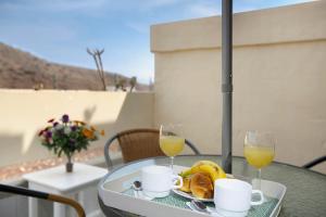 a table with a tray of food and two glasses of orange juice at Silent Flat in Puerto Rico de Gran Canaria
