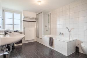 a white bathroom with a tub and a sink at Ferienwohnung am Hopfengarten in Tettnang +21 photos