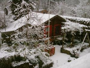 a house covered in snow with a tree at Privatzimmer R und C Lohnherr in Lehnin