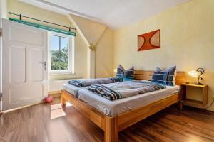 a bedroom with a bed with blue pillows and a window at Kranichblick in Lüdershagen