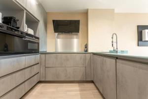 a kitchen with stainless steel cabinets and a sink at Villa Alpaga Esterel Vue Mer in Saint-Raphaël