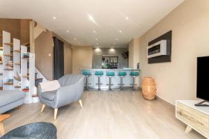 a living room with a bar with blue stools at Villa Alpaga Esterel Vue Mer in Saint-Raphaël