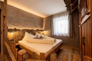 a bedroom with a bed made out of logs at Sonnleiten Sonnenalm in Collepietra +34 photos