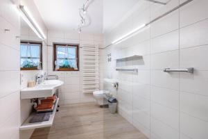 a white bathroom with a sink and a toilet at Cafe-Restaurant-Gästehaus Waldvogel in Feldberg +84 photos