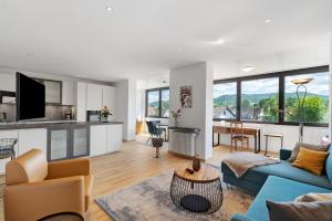 a living room with a blue couch and a kitchen at Modern eingerichtetes Apartment in Achern