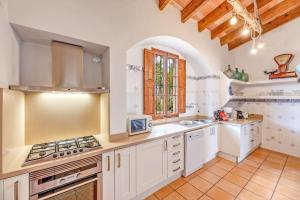 a kitchen with white cabinets and a stove top oven at Finca Buniferri in Llucmajor