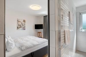 a white bedroom with a bed and a window at Modern eingerichtetes Apartment in Achern