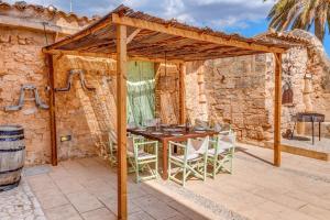 a wooden pergola with a table and chairs on a patio at Finca Buniferri in Llucmajor