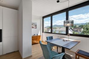 a dining room with a table and chairs and a large window at Modern eingerichtetes Apartment in Achern