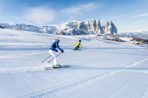 two people are skiing down a snow covered slope at App Ringelblume Biohof Unterspisser in Laion