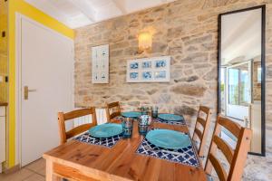a dining room with a wooden table and chairs at La Maison du Gardien in Portsall
