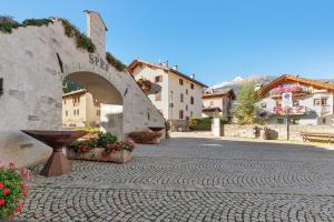 a stone walkway in a small town with flowers at Mansarda Combo in Bormio