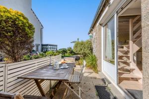 a wooden table on the balcony of a house at La Maison du Gardien in Portsall