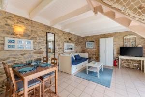 a living room with a table and a couch at La Maison du Gardien in Portsall