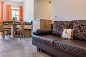 a living room with a leather couch and a table at App Ringelblume Biohof Unterspisser in Laion