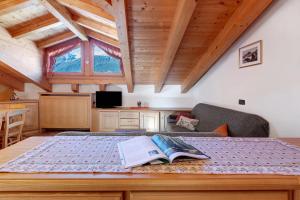 a bedroom with a bed with a book on it at Mansarda Combo in Bormio