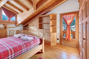 a bedroom with a bed in a wooden house at Mansarda Combo in Bormio