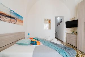 a bedroom with a large bed and a flat screen tv at Kyma monolocale ad Otranto in Otranto