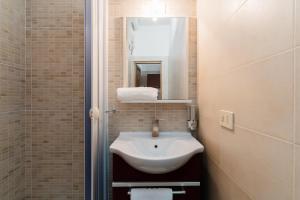 a bathroom with a white sink and a mirror at Kyma monolocale ad Otranto in Otranto +20 photos