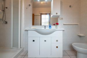 a white bathroom with a sink and a mirror at Casa Colonia 2 in SantʼAnna Arresi
