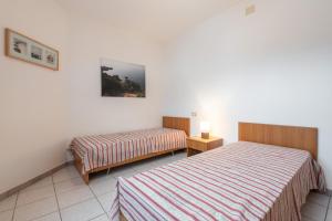 a hotel room with two beds and a lamp at Casa Colonia 2 in SantʼAnna Arresi