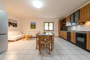 a kitchen and living room with a table and chairs at Casa Colonia 2 in SantʼAnna Arresi
