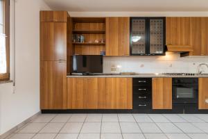 a kitchen with wooden cabinets and a black refrigerator at Casa Colonia 2 in SantʼAnna Arresi +19 photos