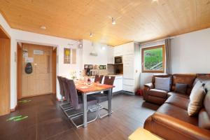 a kitchen and living room with a table and a couch at Joshof Talblick in Moso