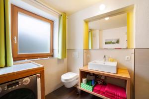 a bathroom with a sink and a toilet and a mirror at Joshof Talblick in Moso +29 photos