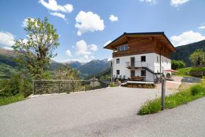 a small white building with a wooden roof at Joshof Talblick in Moso