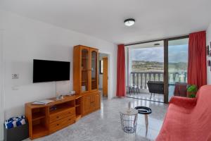 a living room with a flat screen tv and a red couch at El Granero in Moya