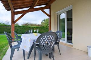 a dining table and chairs on a patio at Le Perchoir Avec Piscine et Clim in Savignac-les-Églises