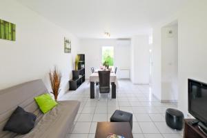 a living room with a couch and a table at Le Perchoir Avec Piscine et Clim in Savignac-les-Églises