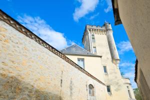 a castle with a tower on top of a building at Le Perchoir Avec Piscine et Clim in Savignac-les-Églises