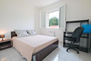 a bedroom with a bed and a desk and a chair at Le Perchoir Avec Piscine et Clim in Savignac-les-Églises +19 photos