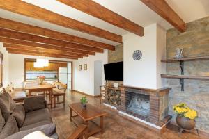 a living room with a fireplace and a tv at Cal Colom - Agroturisme in Puigreig