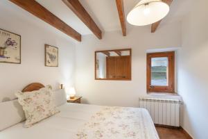 a bedroom with a white bed and a window at Cal Colom - Agroturisme in Puigreig +24 photos