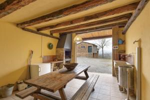 a kitchen with a wooden table in a room at Cal Colom - Agroturisme in Puigreig