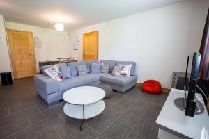 a living room with a blue couch and a table at Chalet Clemalou 14-15 Personnes in Châtel