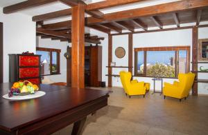 a living room with a table and yellow chairs at Villa Haere Mai in La Asomada